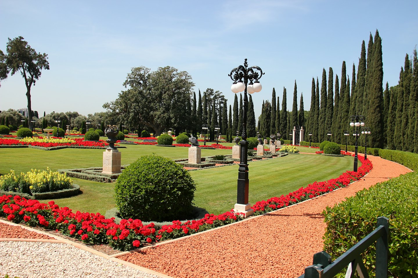Ein gewundener Schotterweg führt durch einen strukturierten Garten mit Blumen.